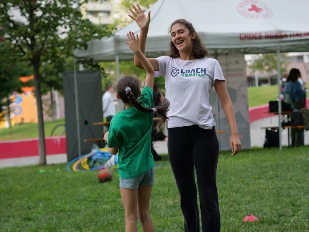 Fotografia di una volontaria di coach di Quartiere con una bambina