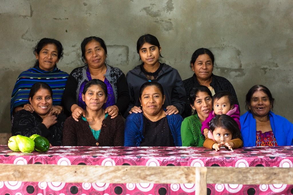Foto di un gruppo di donne Maya della cooperativa sedute davanti a un tavolo 